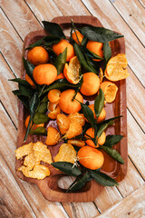 Ripe tangerines on the background of a wooden table. Assembled juicy tangerine in close-up. Delicious citrus fruits for juicing