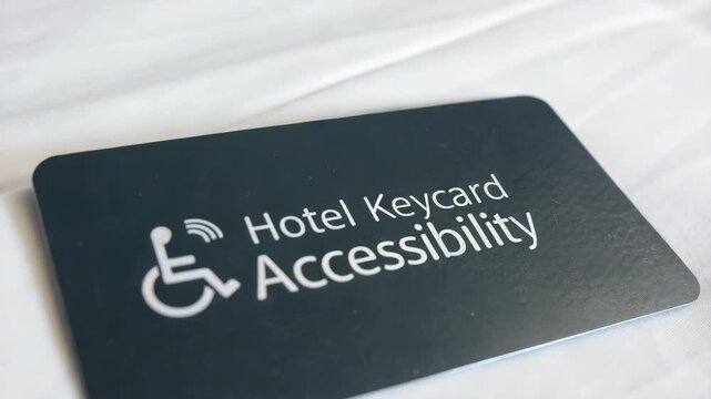 Inclusive travel  promotion concept. A hotel keycard focused on accessibility for people with disabilities, placed on a white sheet.