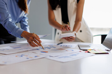 Financial analysts analyze business financial reports on a digital tablet planning investment...