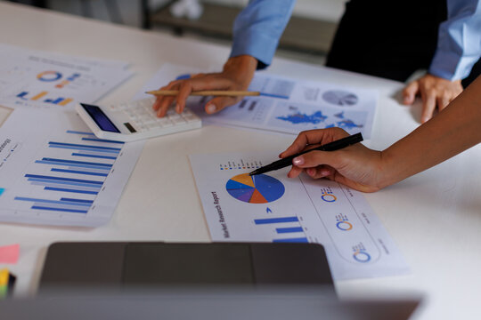 Financial analysts analyze business financial reports on a digital tablet planning investment project during a discussion at a meeting of corporate showing the results of their successful teamwork.	