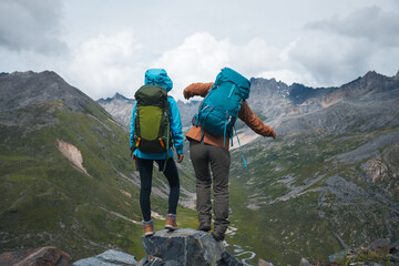 Two hiking friends enjoy the view on high altitude mountain top