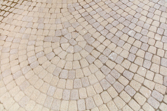 A white and gray tile floor with a circular pattern