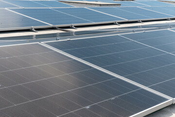 A rooftop covered with solar panels under a bright sky, set against a backdrop of high-rise...