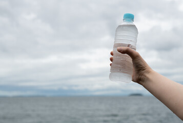 水のペットボトルを持っている人	