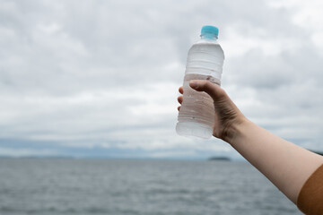 水のペットボトルを持っている人	