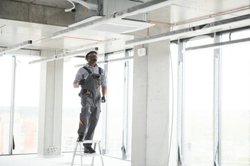 Professional repairman installing air conditioner in a room