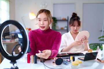 Asian Women Creating Makeup Tutorial for Beauty Vlogs with Ring Light and Various Cosmetics Products for Social Media Content Creation at Home