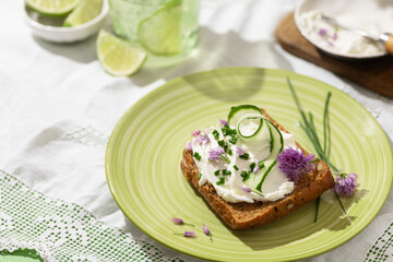 Homemade rye bread with cottage cheese and organic chives onions on green plate. Local organic food...