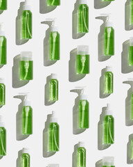 Cosmetic bottles with green liquid for skin care, beauty routine, skin health. Beauty product face lotion, facial cleanser, toner, soap, mockup, natural organic cosmetics, minimal style pattern