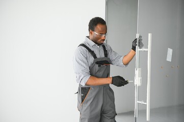 Worker installing glass door at office