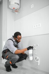 African american plumber change the water filter.