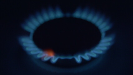 A close view of a vivid blue gas flame on a stove, showcasing its vibrant color and heat