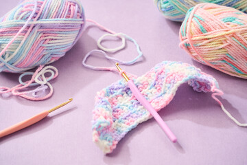 パステルカラーの毛糸でかぎ針編みをする編み物のイメージ