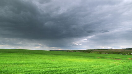 Gloomy Skies Hovering Above Lush Green Fields That Stretch Far and Wide Into the Horizon Time lapse.