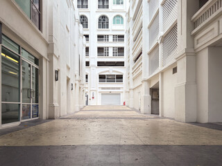 Empty alleyway in a commercial building with white walls and glass doors