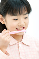 歯磨きをするパジャマ姿の女の子