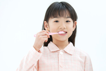 歯磨きをするパジャマ姿の女の子