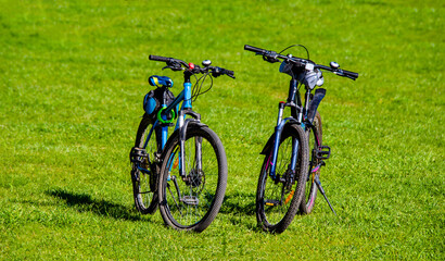Two bicycles are standing on the grass