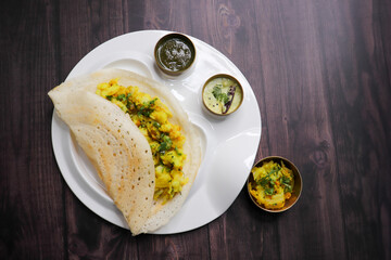 Crispy Masala dosa is a popular South Indian food item served with tomato chutney, coconut chutney, spicy potato masala, or aloo ki sabzi and sambar. Copy space. Crunchy Rice crepes.