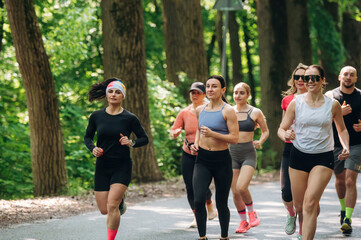 Front view. Group of runners are together outdoors