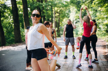 Person is standing. Group of runners are together outdoors