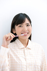 歯磨きをするパジャマ姿の女性