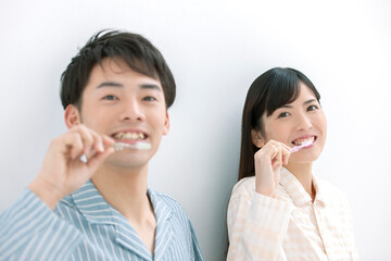 歯磨きをするパジャマ姿の夫婦