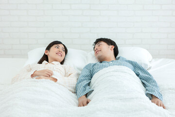 ベッドで話すパジャマ姿の夫婦