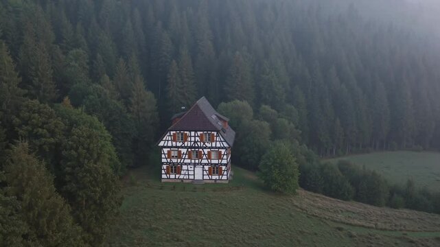Traditional timbered house nestled in a misty forest