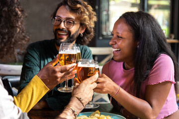 Friends toasting with beer glasses at pub