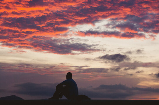 Silhouette of a person celebrating at sunset