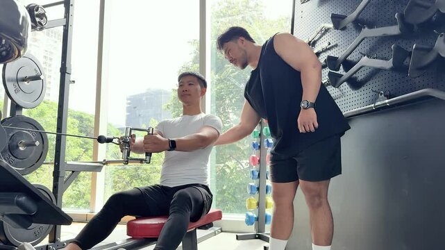 Personal Trainer Assisting Client in Gym Workout