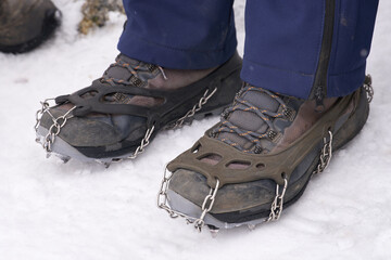 climber standing on mountain glacier, wearing mountaineering boots equipped with crampons.