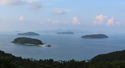 Scenic coastal view of several forested islands surrounded by calm blue ocean waters