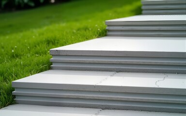 Concrete structure steps detail with horizontal lines and granular texture, contrasting with green grass. Ideal for landscape architecture, urban design, and sustainability themes in Brazil