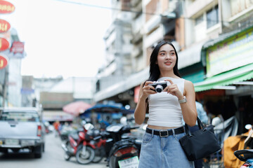 Tourist taking pictures in a crowded street market in thailand