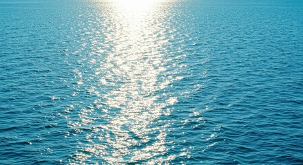 Obraz premium Sparkling sunlight reflecting on the calm blue surface of the ocean water