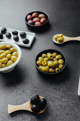 Close view of assorted olive types, green, black and kalamata olives  on dark background