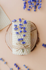 Beeswax candle with lavender tied on wood slice flatlay