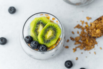 Healthy granola parfait with kiwi and blueberries in glass