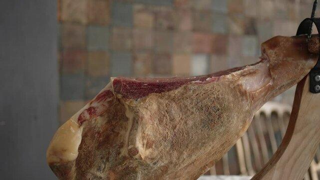 cured presunto ham leg on wooden holder ready for slicing indoors