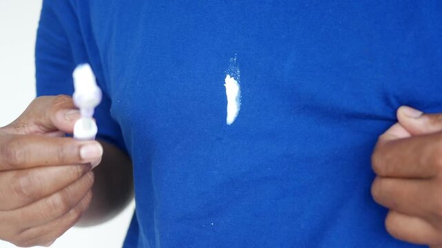 tooth paste spilled on a shirt while holding a tooth brush 