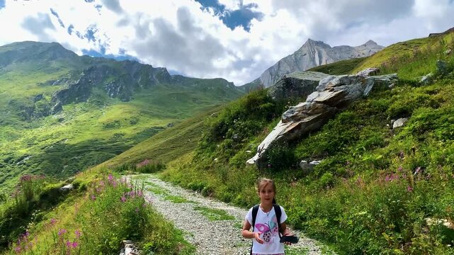Una giovane ragazza percorre un sentiero in montagna