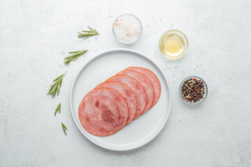 Sliced sausage on white plate with herbs and spices