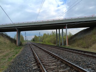 Two way railway tracks and bridge. Two railroad tracks. Concrete bridge. Cloudy day. Countryside....