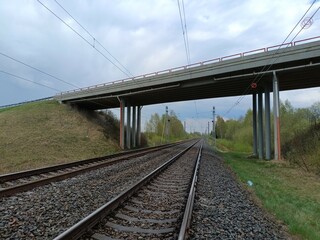 Two way railway tracks and bridge. Two railroad tracks. Concrete bridge. Cloudy day. Countryside....