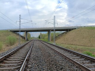 Two way railway tracks and bridge. Two railroad tracks. Concrete bridge. Cloudy day. Countryside....