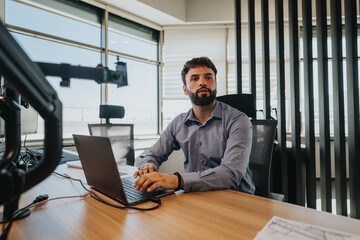 Business employee in modern office working on a laptop, surrounded by professional equipment. The...