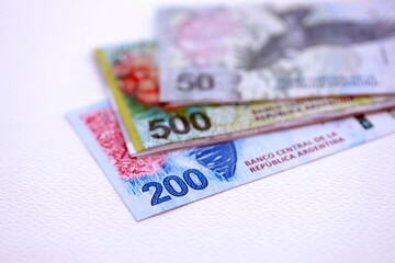 Argentine pesos money bills in big amount lies on white table close up