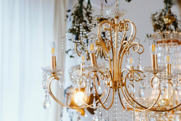 Elegant chandelier with crystals illuminated in a bright indoor space
